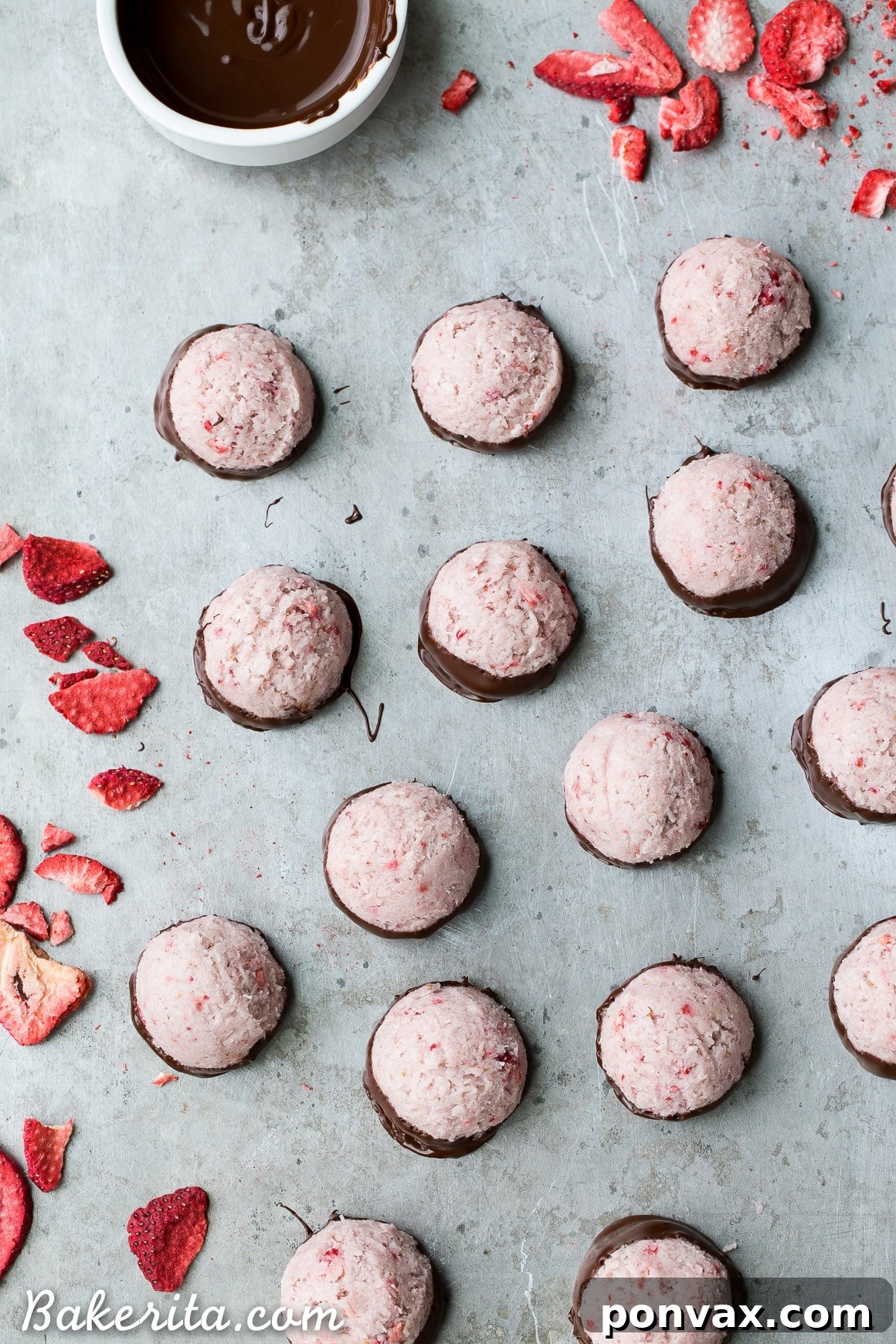 No Bake Vegan Chocolate Covered Strawberry Macaroons 4 A selection of creamy No-Bake Chocolate Dipped Strawberry Macaroons arranged on parchment paper, ready to be enjoyed.