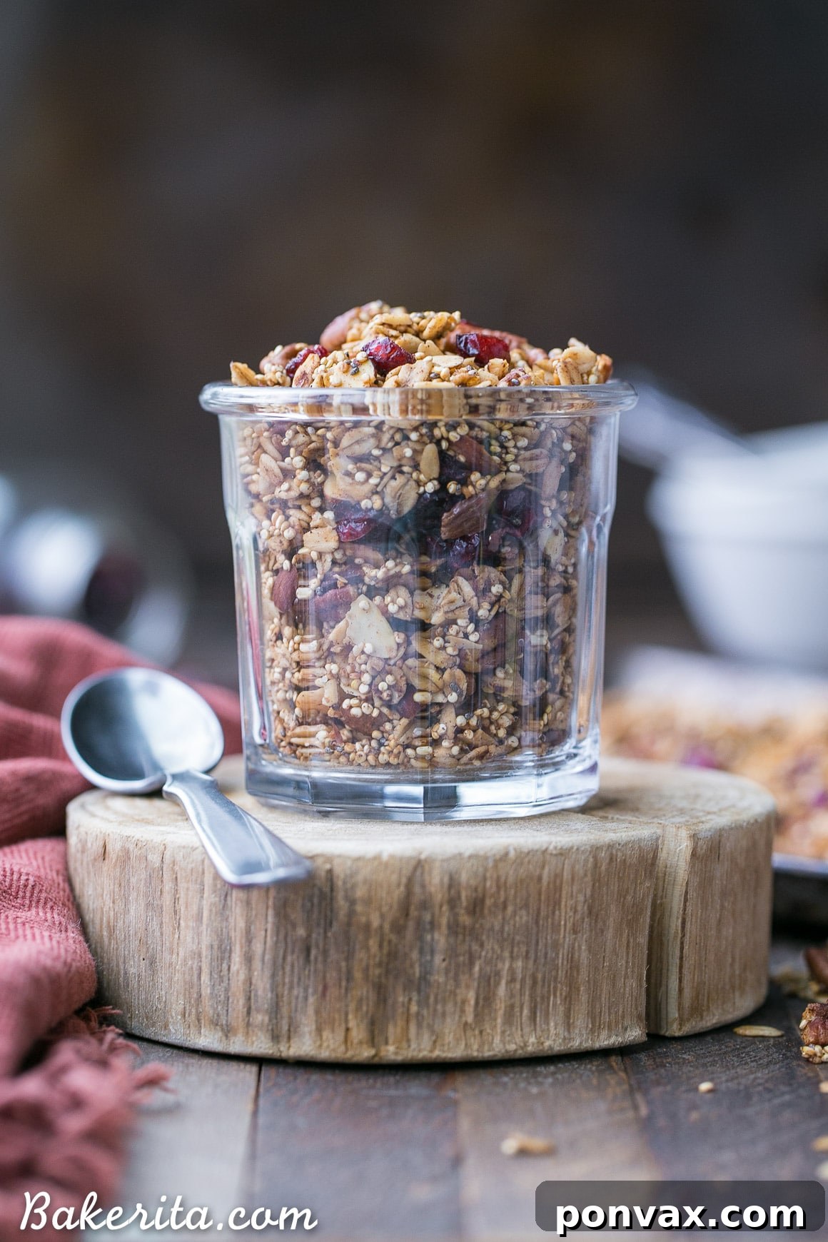Wholesome Vegan Gluten Free Quinoa Granola 5 A hand reaching for a spoonful of Quinoa Granola, highlighting its irresistible crunch and cluster formation.