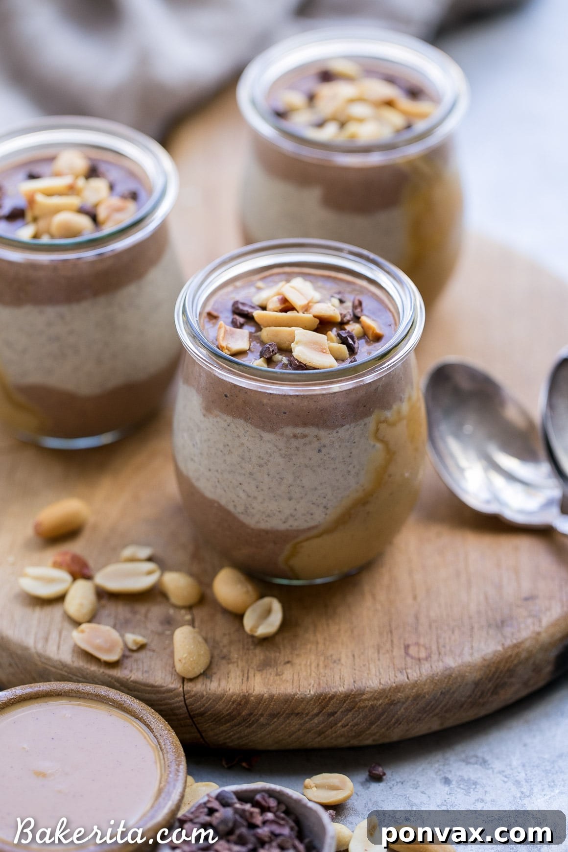 A beautifully layered Chocolate Peanut Butter Chia Pudding, showing distinct chocolate and peanut butter segments in a small glass jar, ready for garnishing.