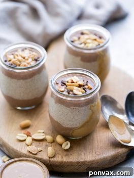 A layered chocolate and peanut butter chia pudding with garnishes, presented in a small glass jar.