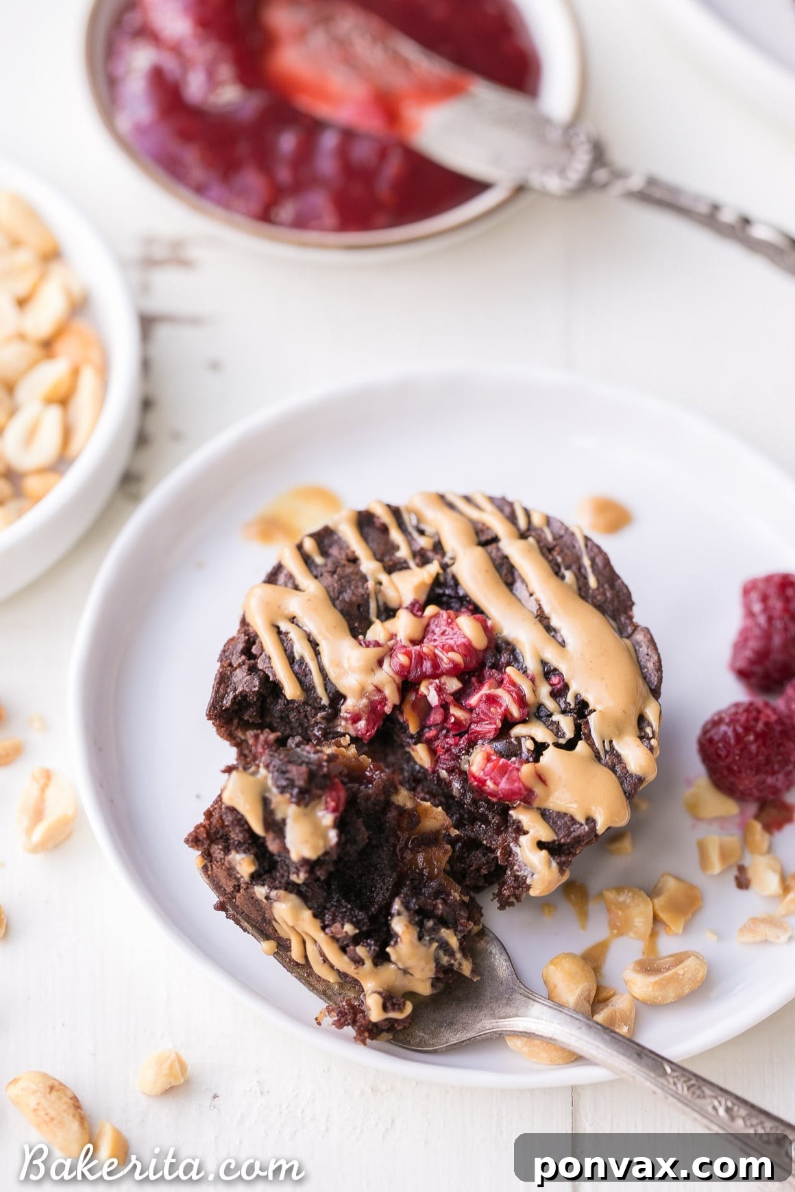 A single gluten-free peanut butter and jelly brownie bite, halved to reveal the creamy peanut butter and sweet raspberry jam core.
