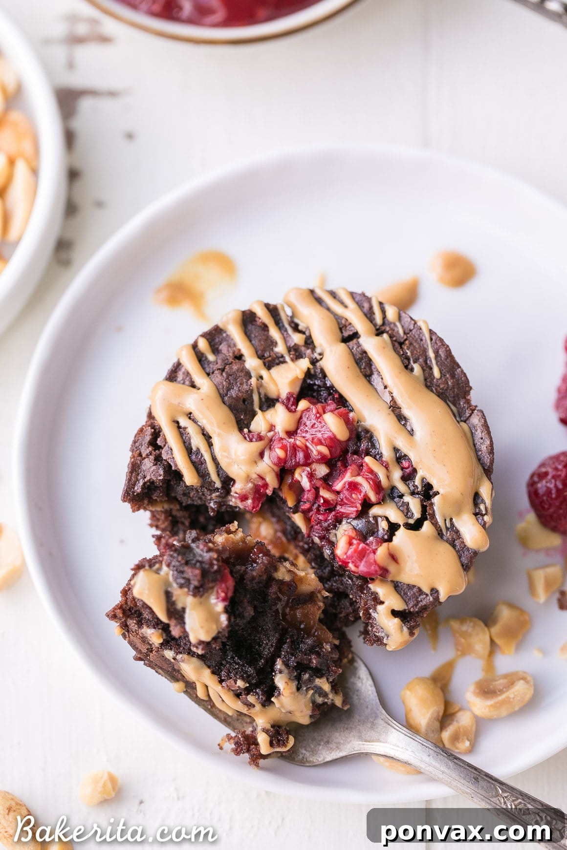 Preparing gluten-free brownie bites, with brownie batter, peanut butter, and raspberry jam layered in muffin cups.