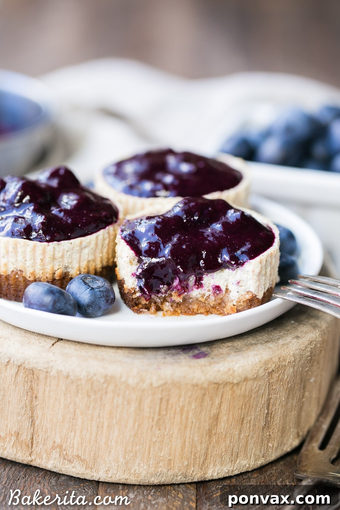 Close-up of a delightful Vanilla Bean Greek Yogurt Cheesecake topped with fresh blueberry compote and a sprig of mint, showcasing its creamy texture and vibrant colors.