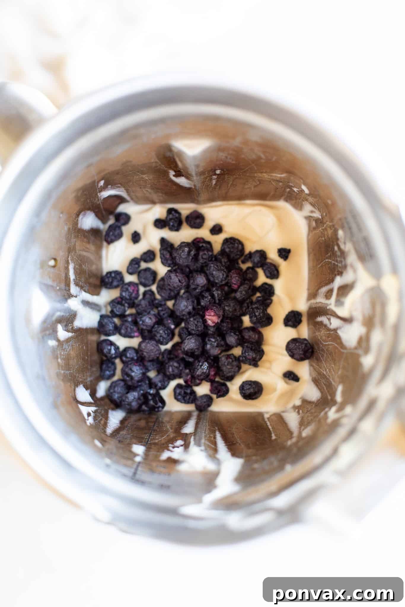A slice of no-bake layered blueberry vegan cheesecake on a small plate, revealing its creamy texture and distinct layers.