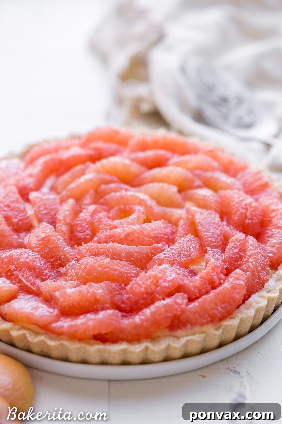A vibrant close-up of the fresh, ruby red grapefruit segments delicately placed atop the creamy curd.