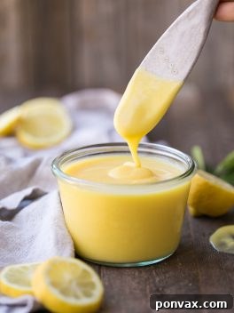 A beautifully styled shot of Paleo Lemon Curd in a small bowl with fresh lemon slices, ready to be served.