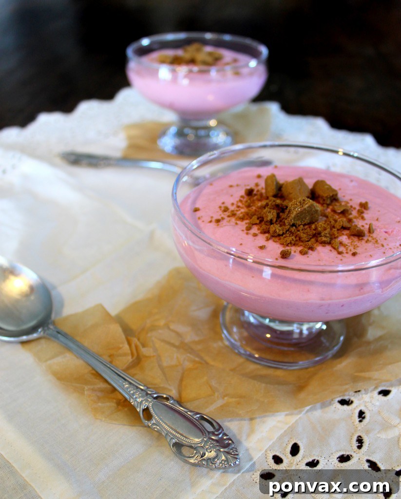 Rich and creamy Blackberry Mousse dessert topped with crunchy gingersnap crumbs, served in a glass.