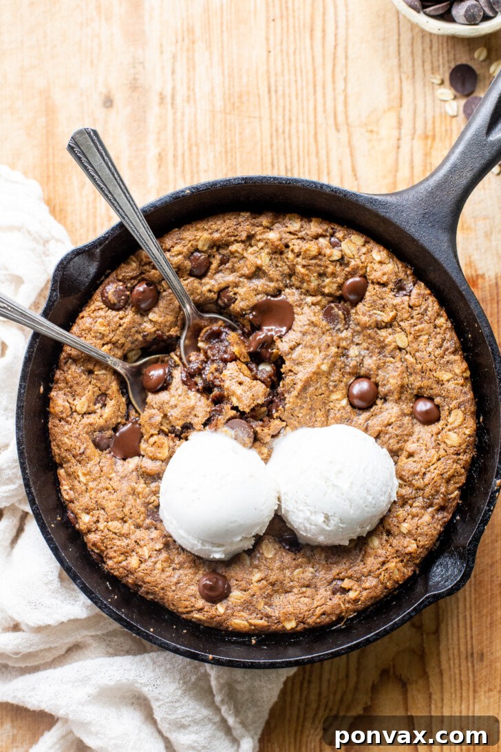 Gluten-Free Oatmeal Chocolate Chip Skillet Delight 2 A warm, gooey Gluten-Free Vegan Oatmeal Chocolate Chip Skillet Cookie, fresh out of the oven in a cast iron pan, topped with melting chocolate chips.
