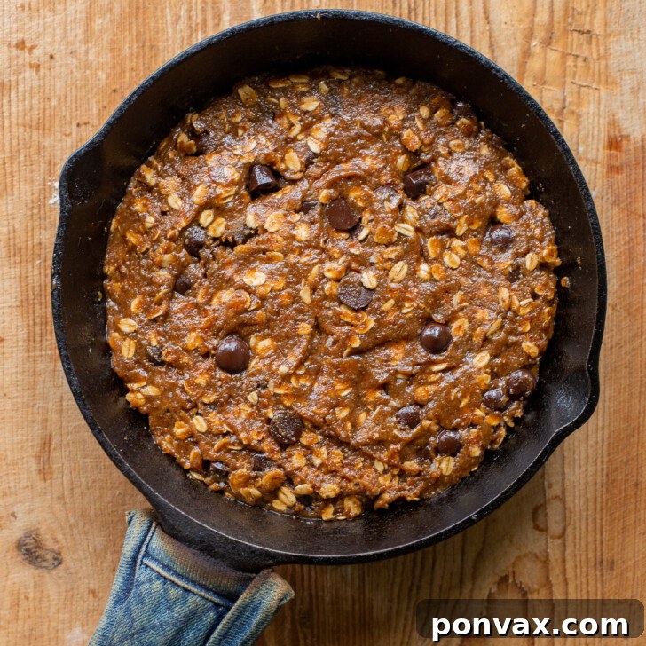 Gluten-Free Oatmeal Chocolate Chip Skillet Delight 14 Image showing the cookie dough pressed into a cast iron skillet, ready to bake.