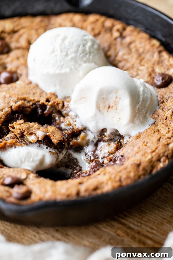 Gluten-Free Oatmeal Chocolate Chip Skillet Delight 17 Two hands reaching for a piece of the warm Gluten-Free Vegan Oatmeal Chocolate Chip Skillet Cookie.
