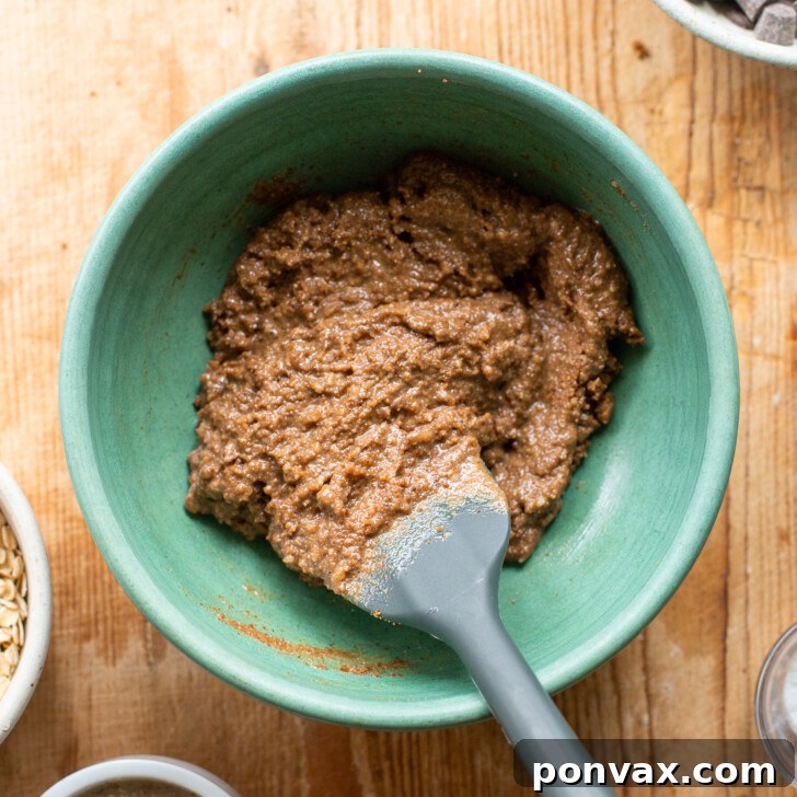 Gluten-Free Oatmeal Chocolate Chip Skillet Delight 7 Image showing flax eggs and vanilla extract being added to the wet ingredients mixture.