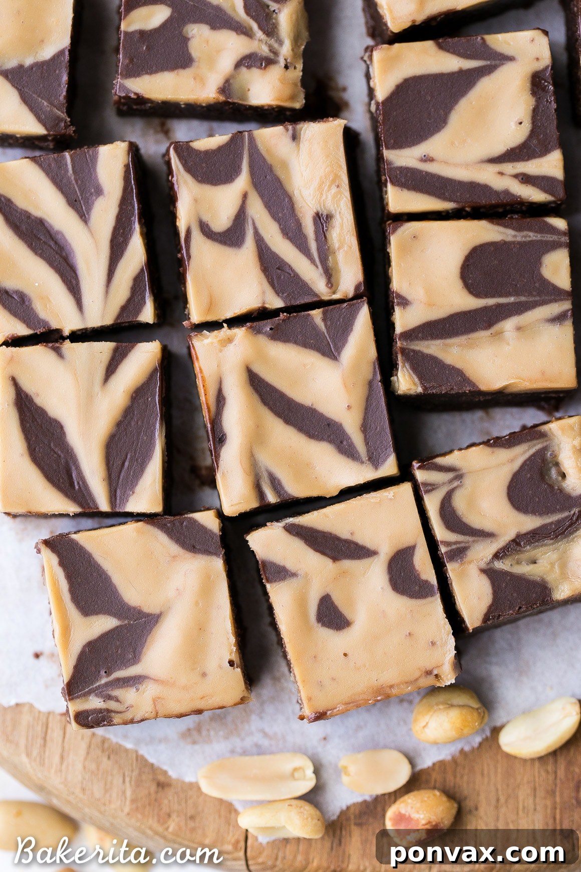 An overhead view of rich vegan chocolate peanut butter fudge with an artful peanut butter swirl on a rustic wooden surface.