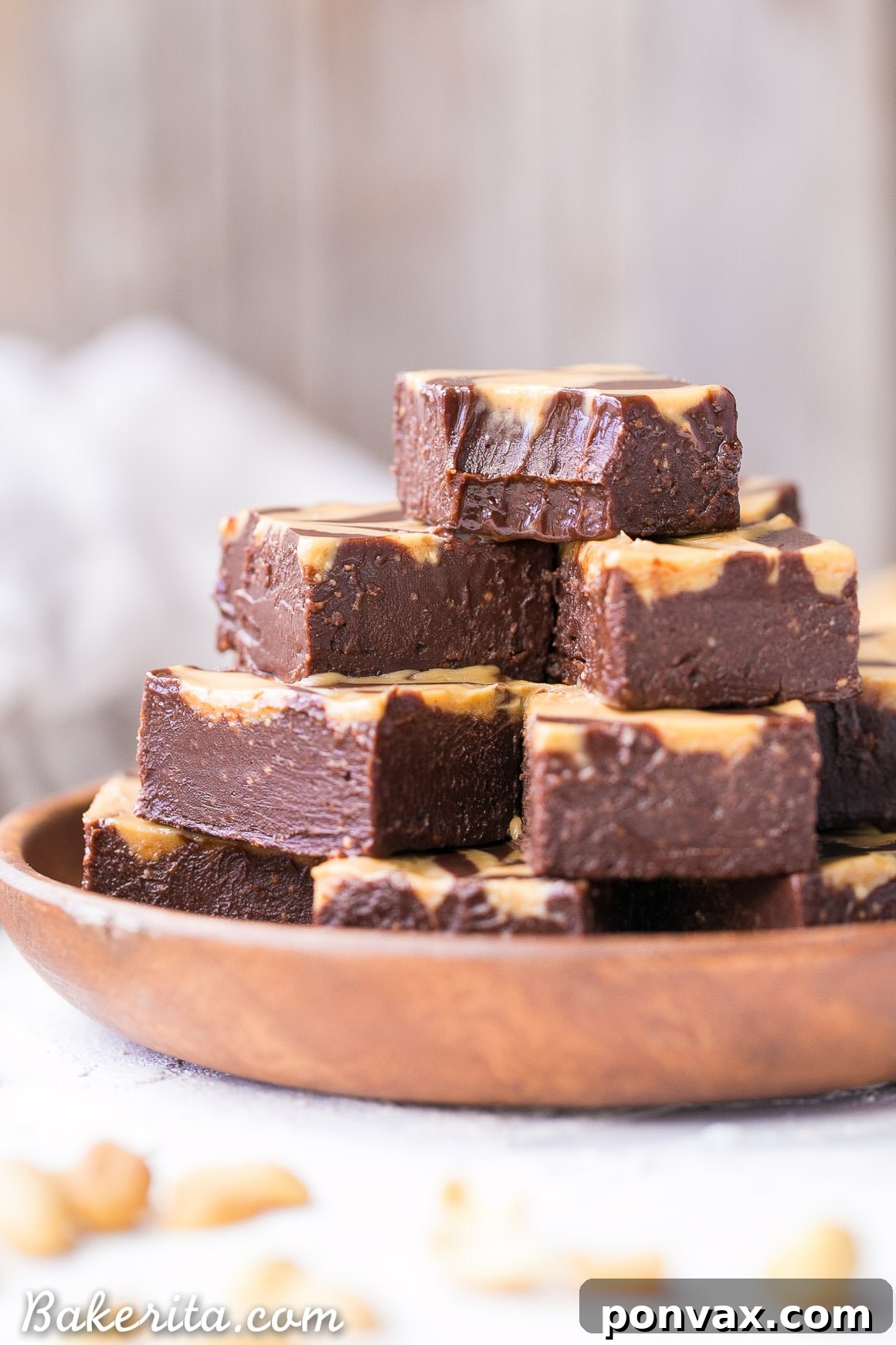 A close-up view of a piece of vegan chocolate peanut butter fudge with a distinct peanut butter swirl, showing the creamy texture and a bite taken out.