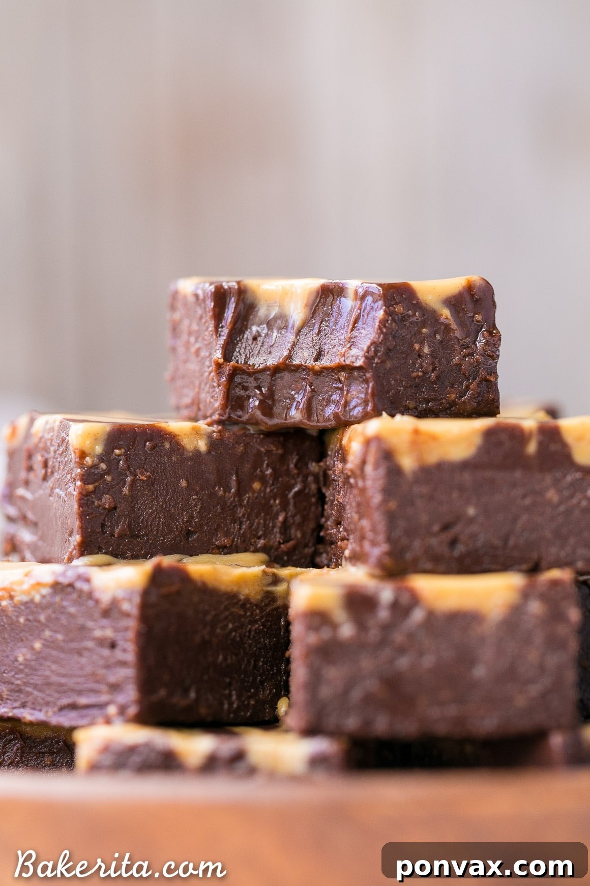 A close-up, mouth-watering photo of chocolate peanut butter swirl fudge, with a piece that has been bitten into, revealing its luxuriously creamy and smooth interior.