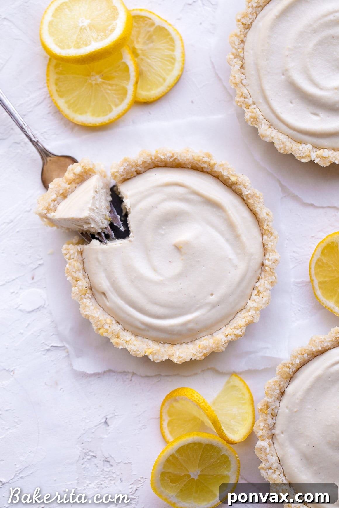 Creamy Vegan No-Bake Lemon Tarts 5 No-Bake Lemon Tart with a fork taking a bite, showing the creamy texture and crumbly crust.