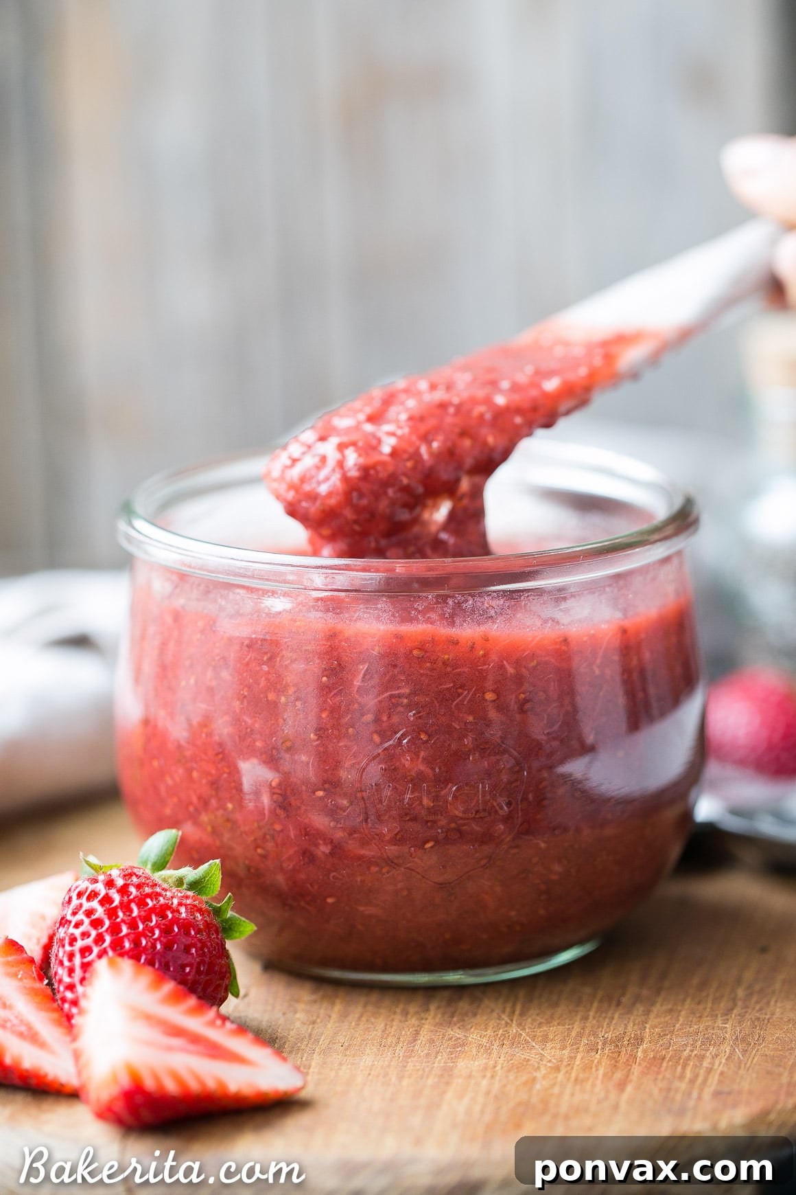 Luscious Paleo Vegan Strawberry Chia Jam 6 A spread of strawberry chia jam on toast, with fresh strawberries and a jar in the background.