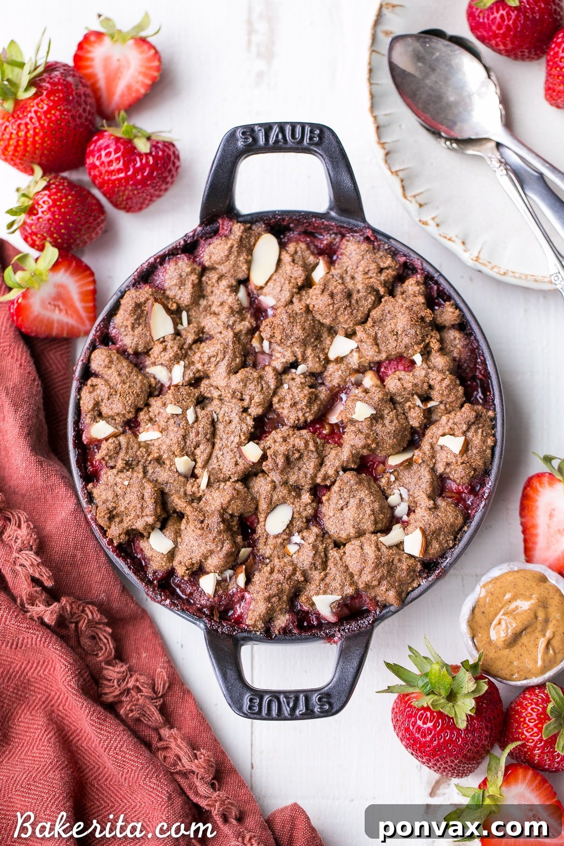 Healthy Indulgence Strawberry Crisp with Almond Butter Crumble 2 Delicious Strawberry Crisp with Almond Butter Crumble in a cast iron skillet, garnished with fresh mint.