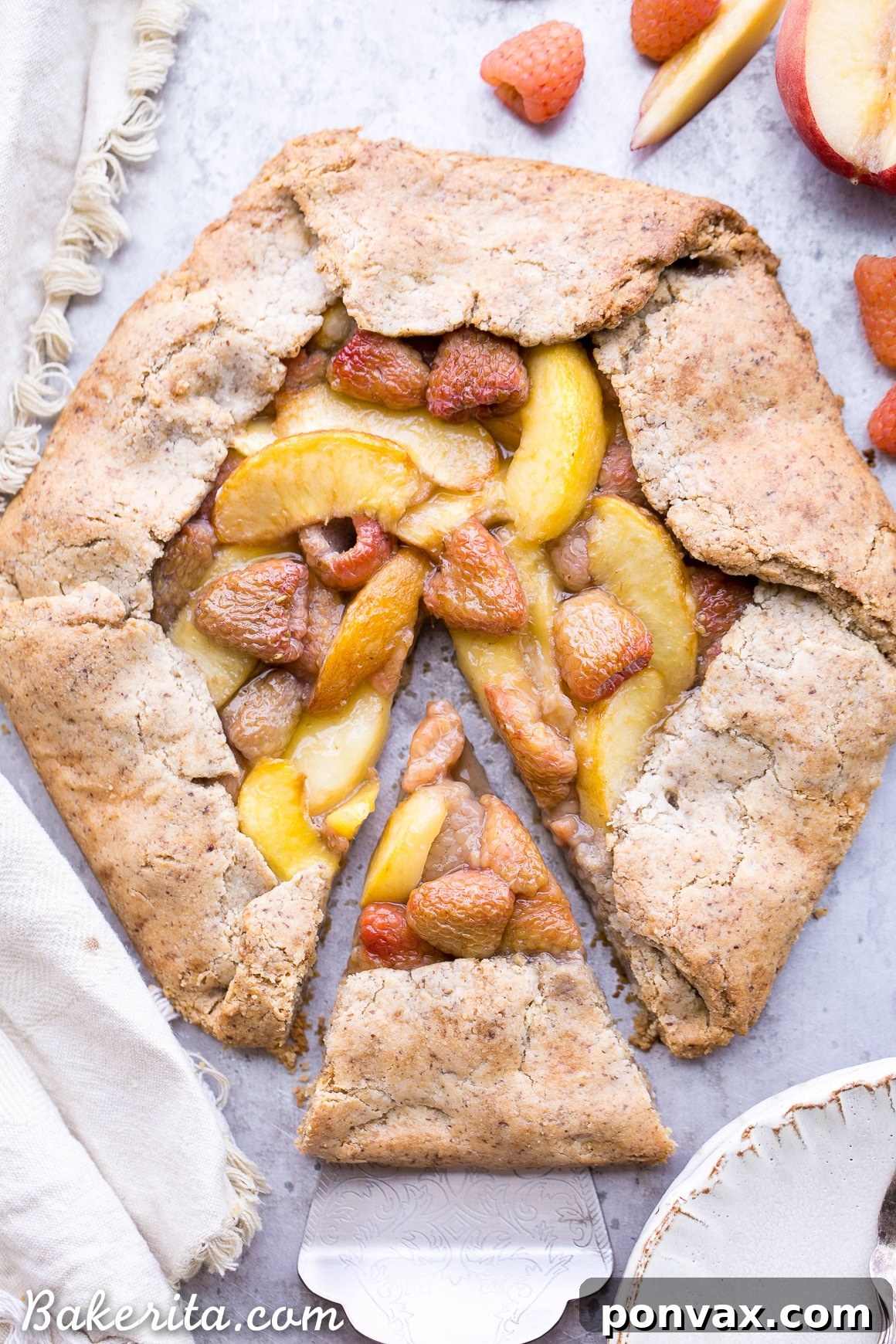 Close-up of a partially baked Vegan Peach Raspberry Galette, showing the golden crust and vibrant peach and raspberry filling bubbling gently.