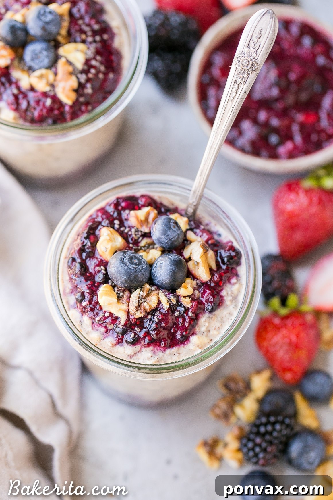 A bowl of Superfood Overnight Oats topped generously with homemade Berry Chia Jam and fresh berries.
