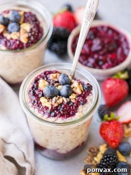 Superfood Overnight Oats with Easy Berry Chia Jam in a glass jar, ready to serve.