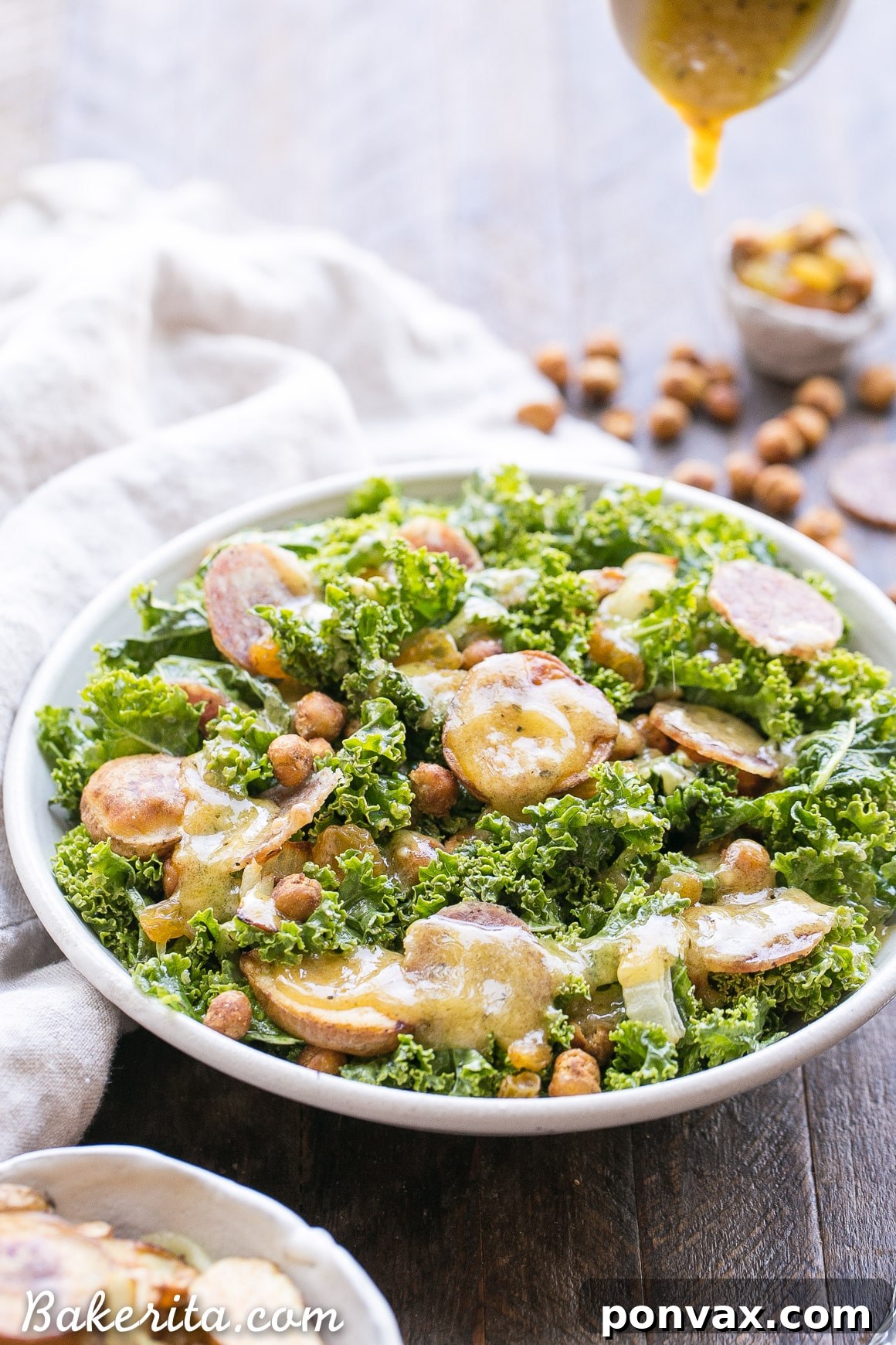 Close-up of Kale & Salami Salad highlighting the roasted fingerling potatoes, crispy chickpeas, and golden raisins tossed in a rich dressing.