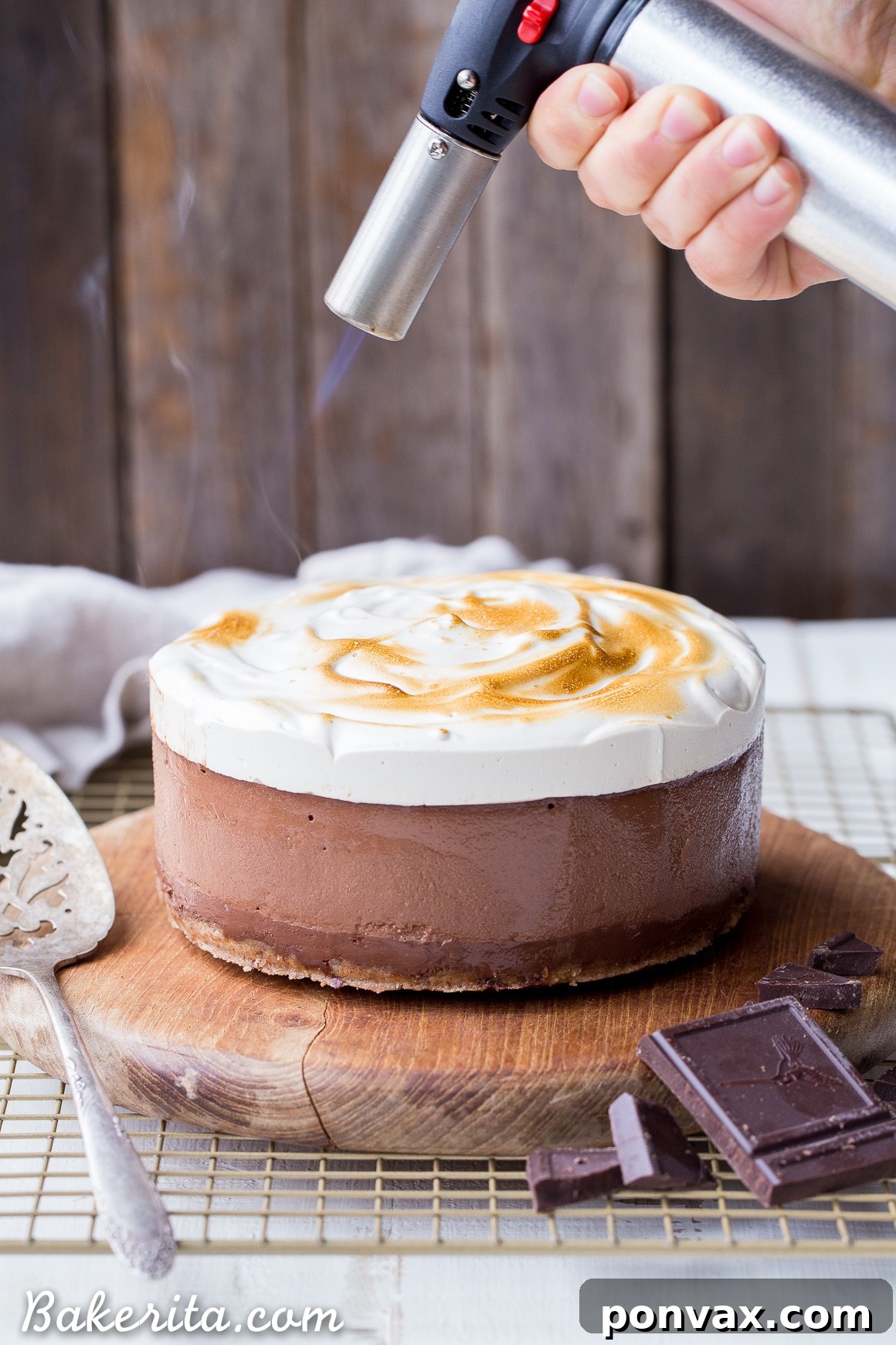Close-up shot of the No Bake S'mores Cheesecake layers: a dark crust, smooth chocolate ganache, creamy chocolate cashew cheesecake, and a delicate marshmallow layer. It's a gluten-free, dairy-free, and Paleo dessert.