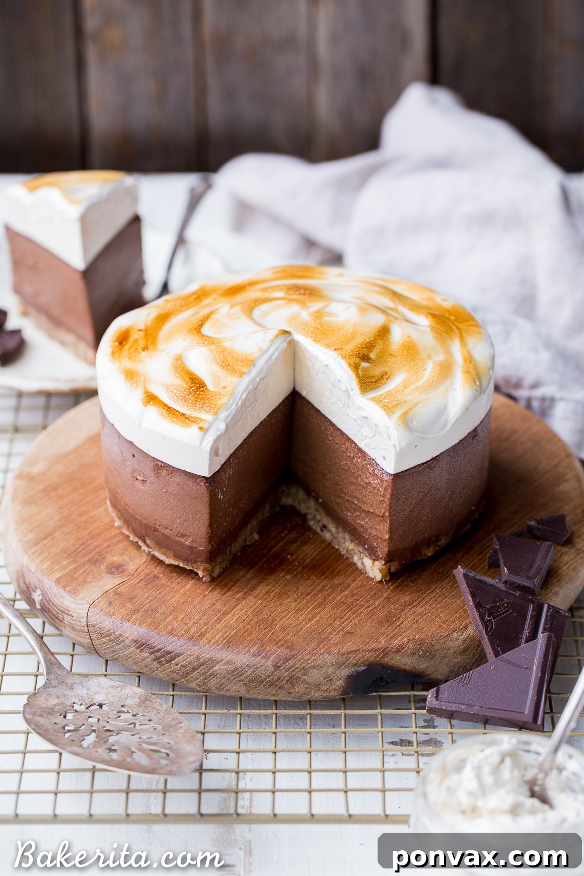 A beautifully sliced No Bake S'mores Cheesecake, revealing all its layers with a perfectly toasted marshmallow topping. This gluten-free, dairy-free, and Paleo dessert is ready to be enjoyed.