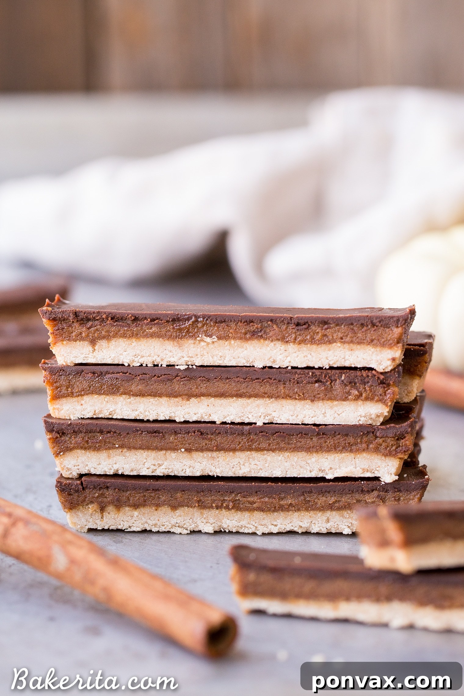 Gluten-Free Vegan Pumpkin Spice Twix Bars 3 Close-up of freshly made Pumpkin Spice Twix Bars, showing the distinct layers of spiced shortbread, gooey caramel, and rich chocolate.
