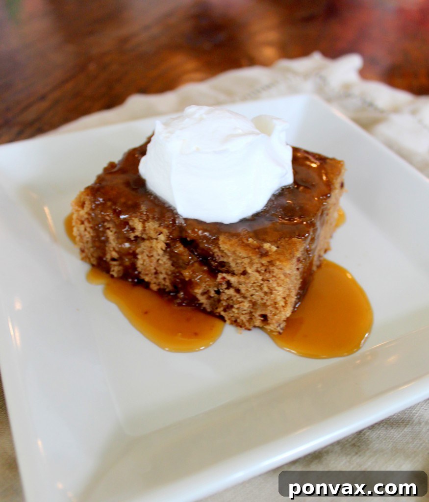 A close-up of Sticky Toffee Pudding, showcasing its rich texture and decadent toffee sauce, served with a scoop of ice cream.