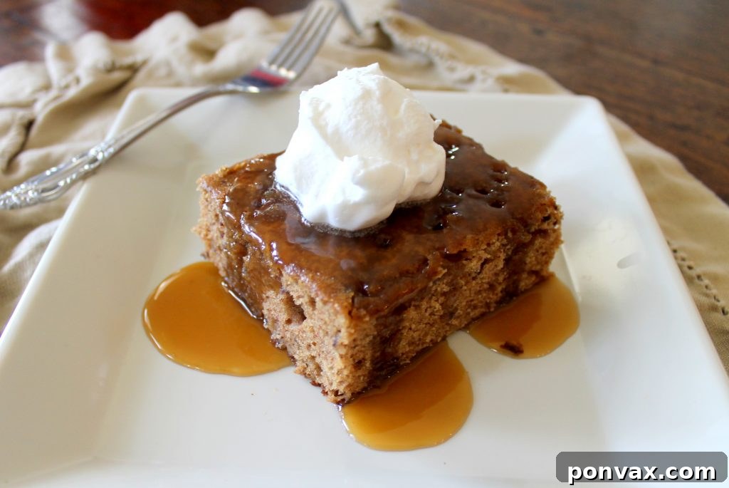 A warm, moist Sticky Toffee Pudding drizzled generously with homemade toffee sauce, ready to be enjoyed.