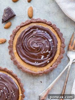 This No Bake Chocolate Almond Butter Tart tastes like a giant almond butter cup! There's no baking required and it's gluten-free, paleo, and vegan. You'll adore this melt in your mouth tart.