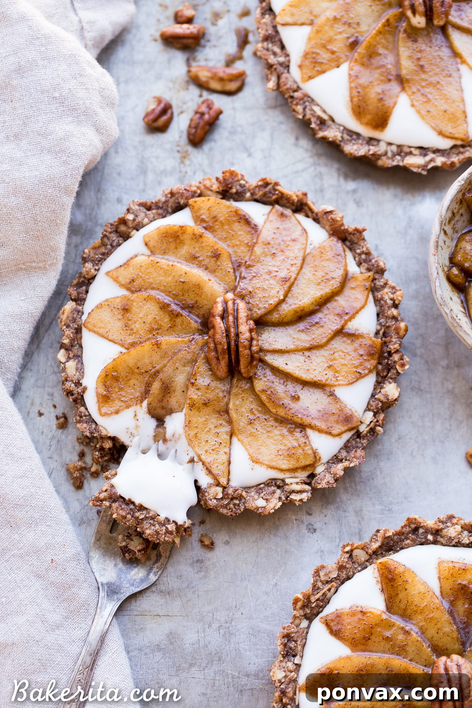 A spoon scooping creamy dairy-free coconut yogurt, ready to be spread over a crisp granola crust in preparation for a delicious breakfast tart.
