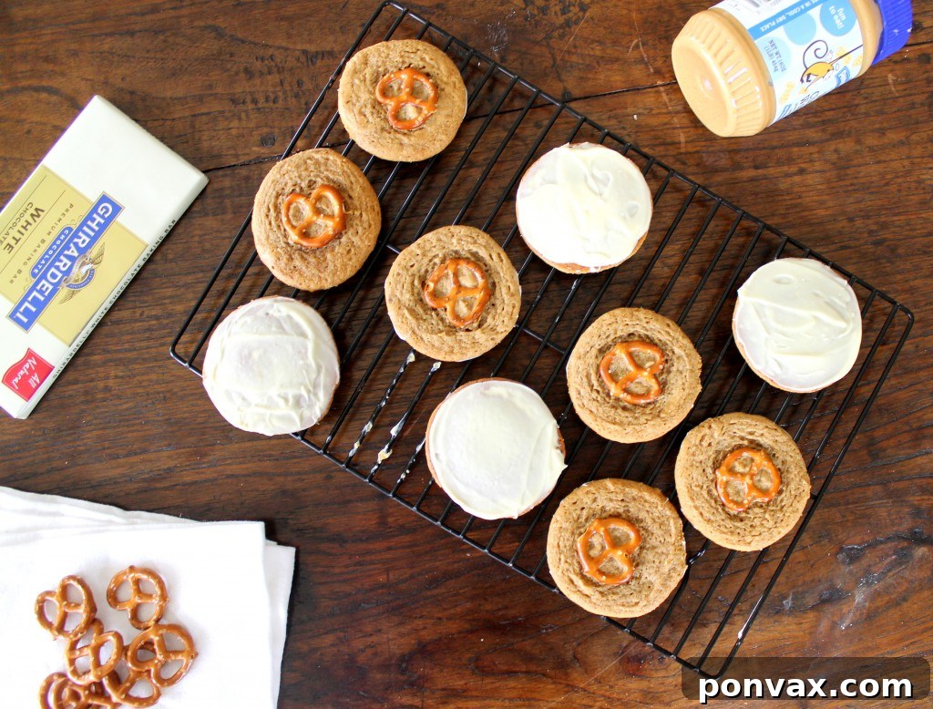 A plate of freshly baked White Chocolate Pretzel Peanut Butter Cookies, some dipped in white chocolate