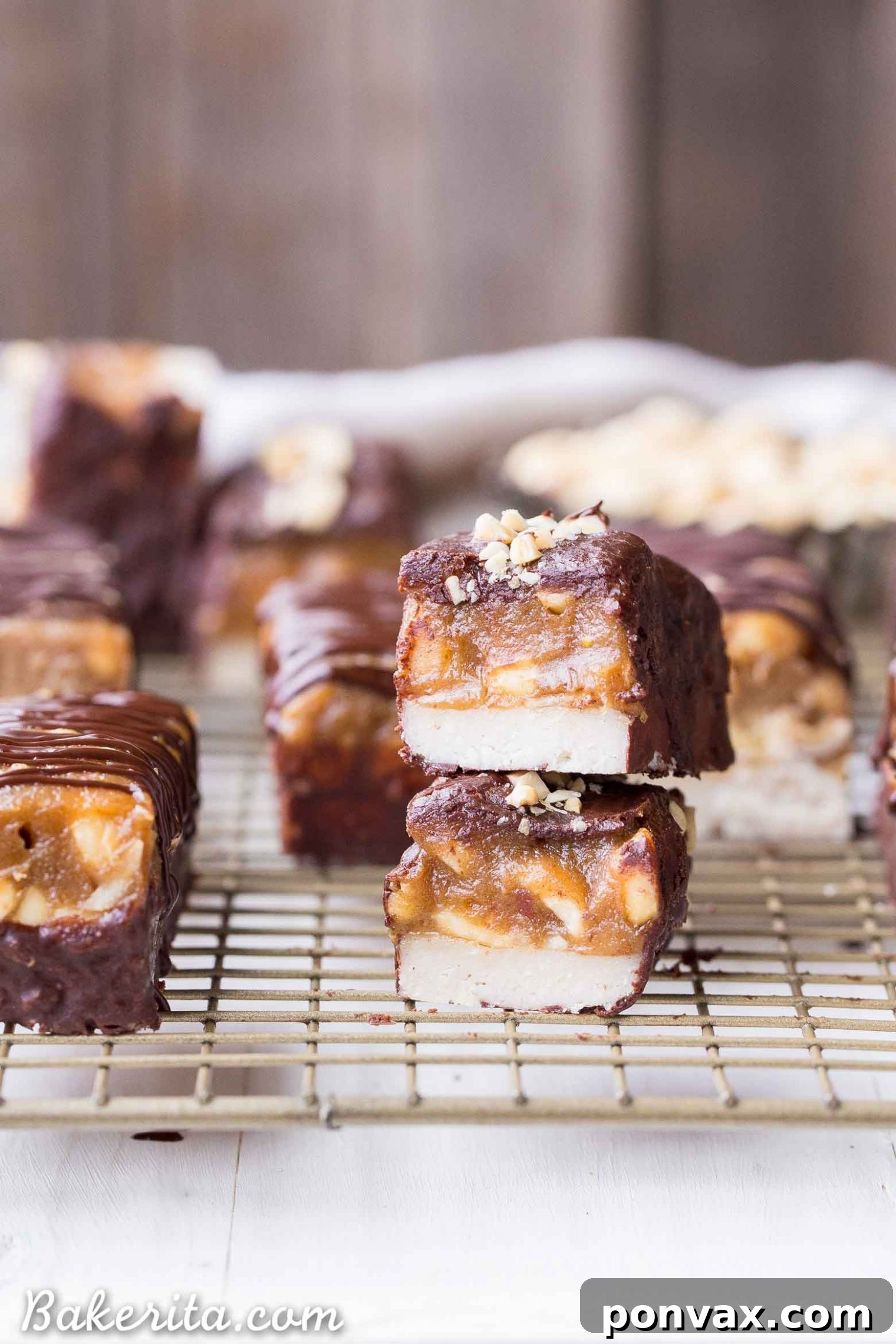 Delicious no-bake homemade Snickers bars, featuring a raw nougat base, peanut date caramel, and chocolate coating.