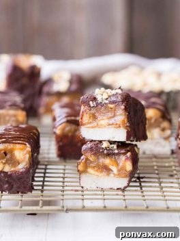These Homemade Snickers Bars are a healthier version of the classic candy with no baking required! These gluten-free and vegan candy bars have a layer of raw nougat, topped with a peanut date caramel, all dunked in homemade chocolate.