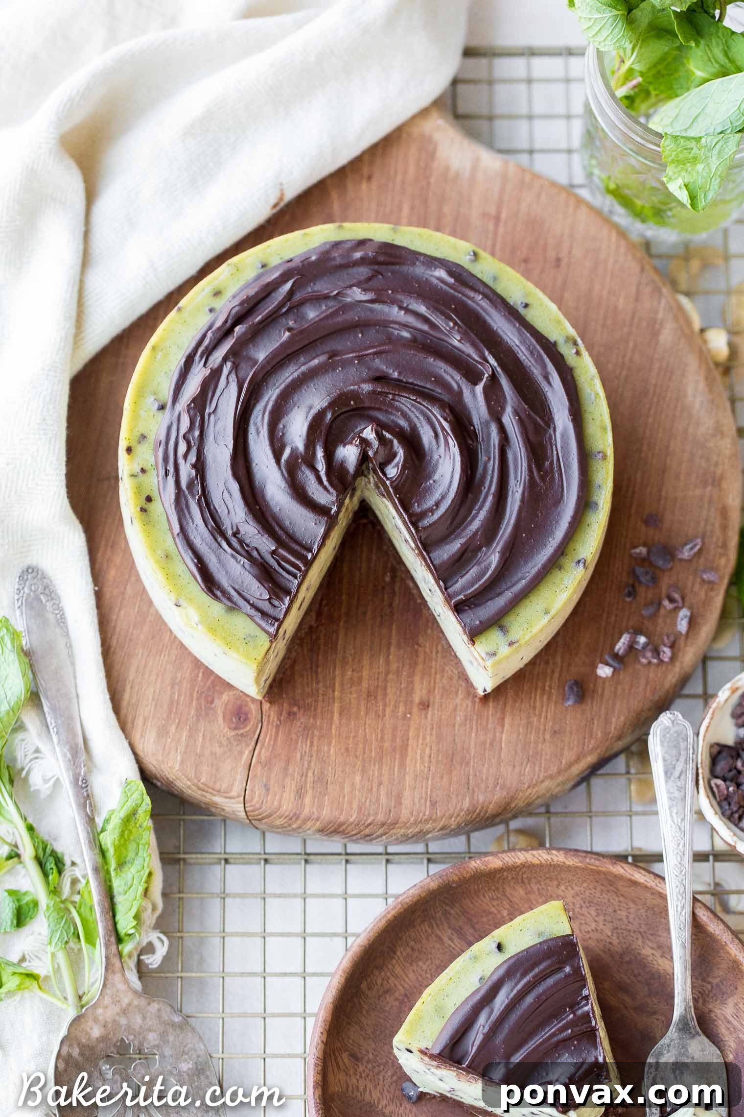 Paleo Vegan Gluten Free No Bake Mint Chip Cheesecake 6 A close-up shot of a single slice of mint chip cheesecake, garnished with fresh mint leaves, on a minimalist white plate.