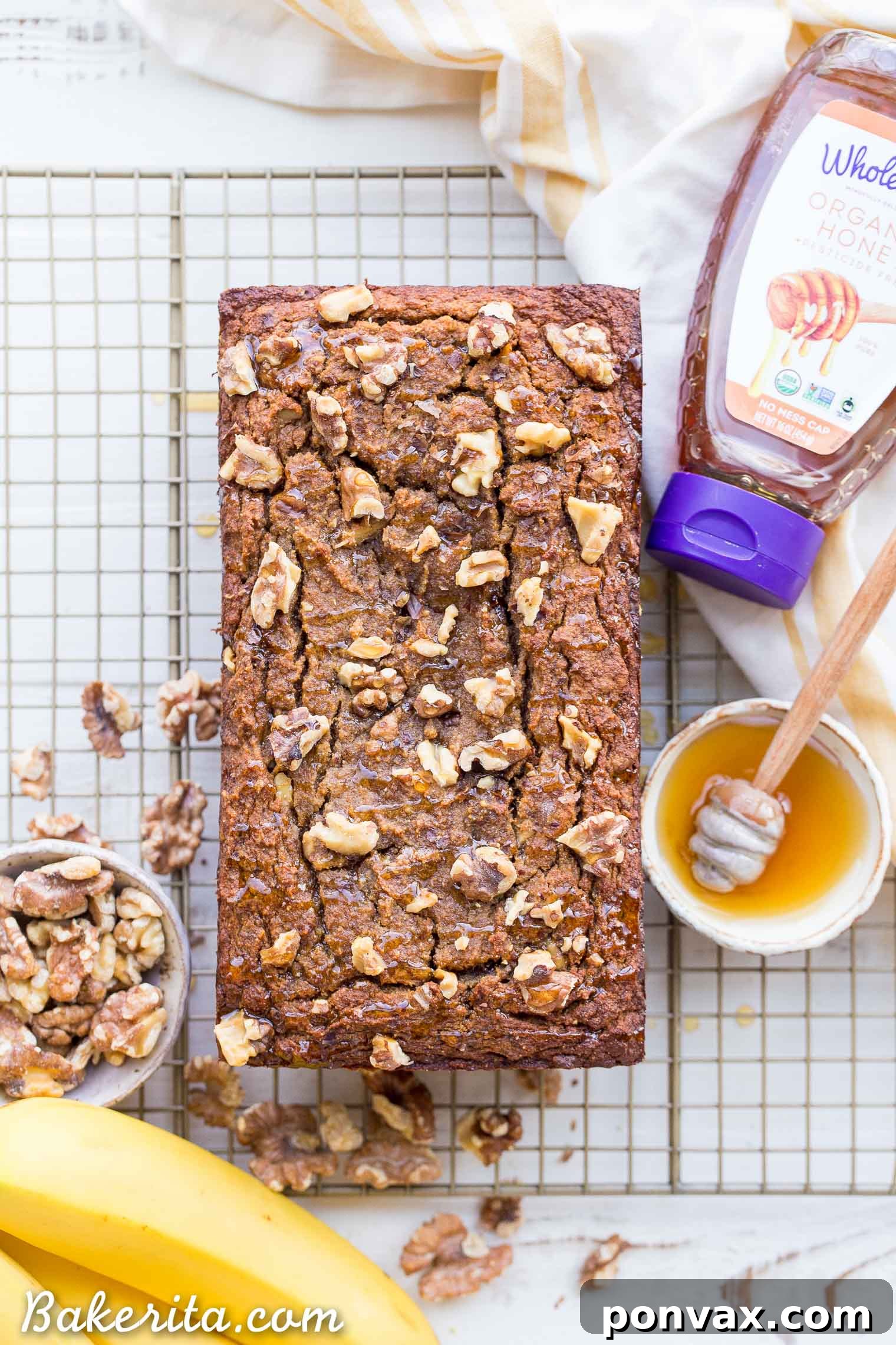 Paleo Golden Honey Nut Banana Loaf 9 Two loaves of Paleo Honey Nut Banana Bread, one whole and one sliced, with fresh bananas.