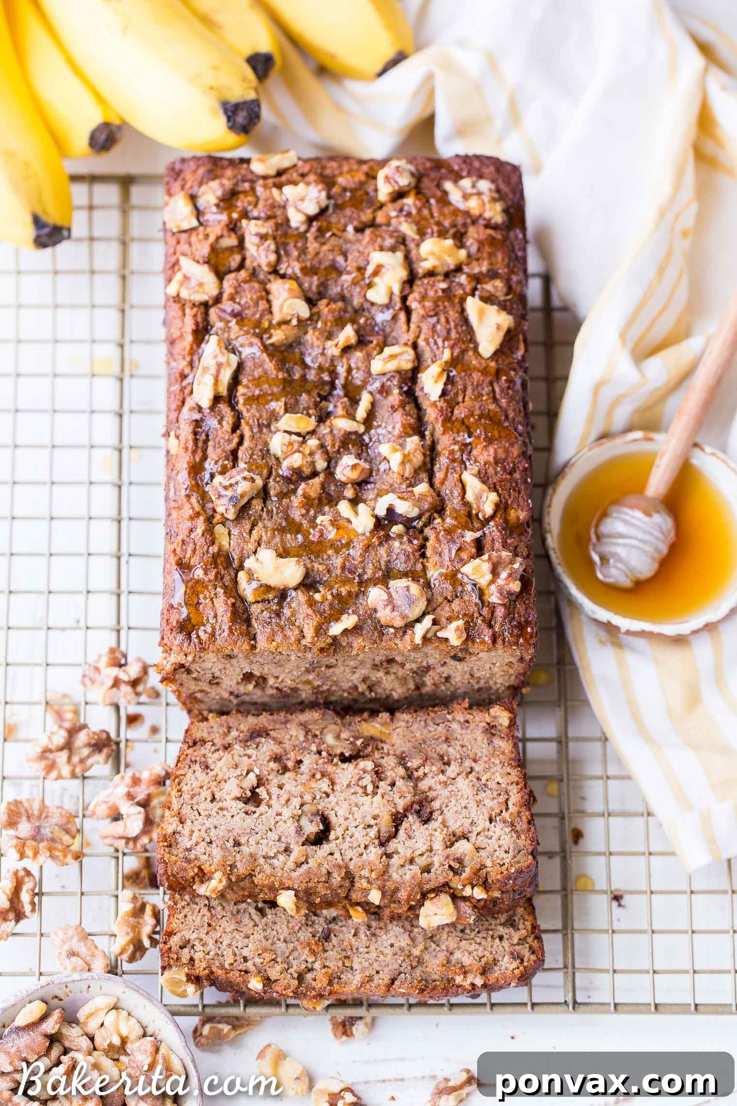 Paleo Golden Honey Nut Banana Loaf 6 A large slice of Paleo Honey Nut Banana Bread, topped with additional walnuts and a honey drizzle.