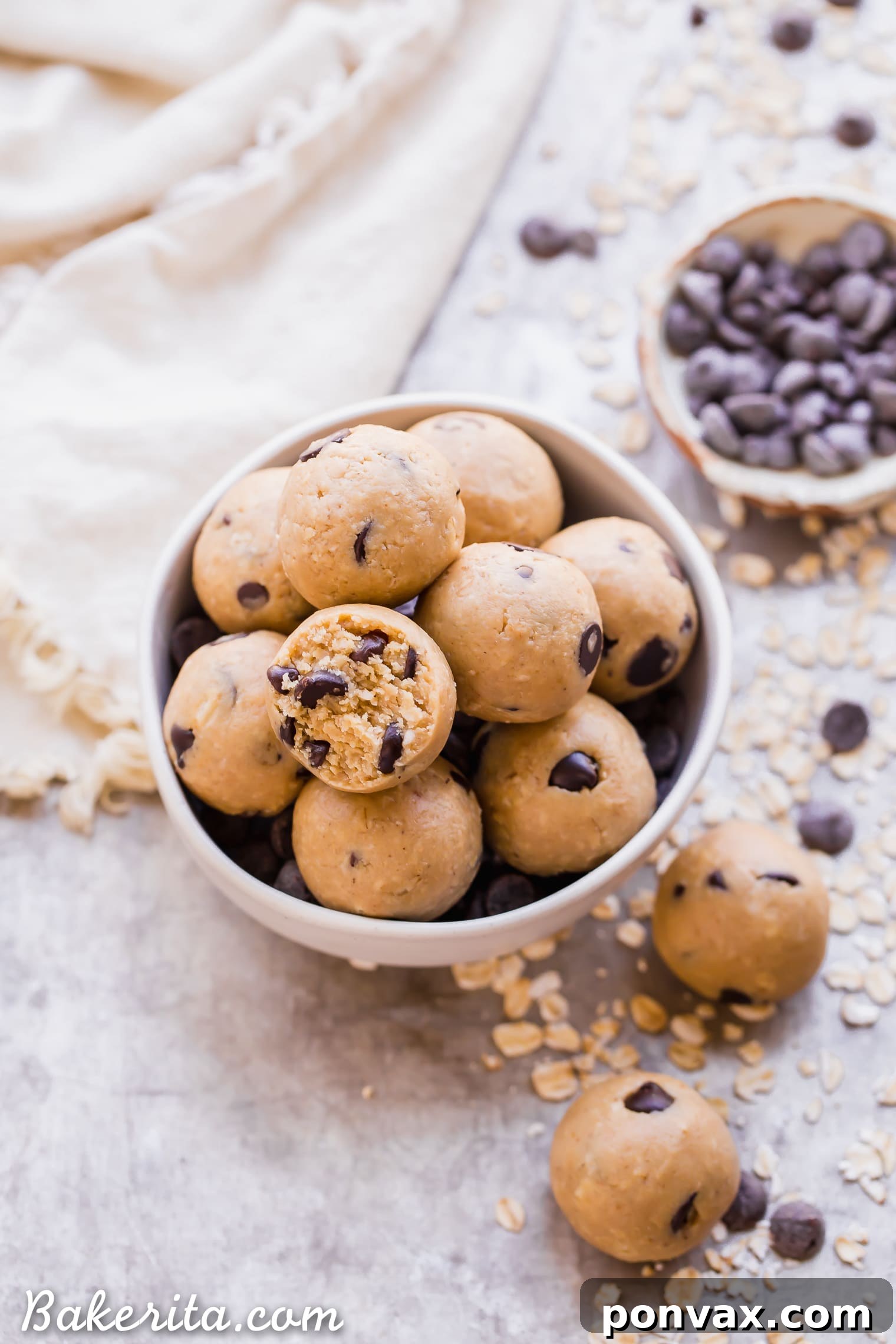 Oatmeal Chocolate Chip Cookie Dough Bites: Gluten Free & Vegan. Stacked in a bowl with oats and chocolate chips.