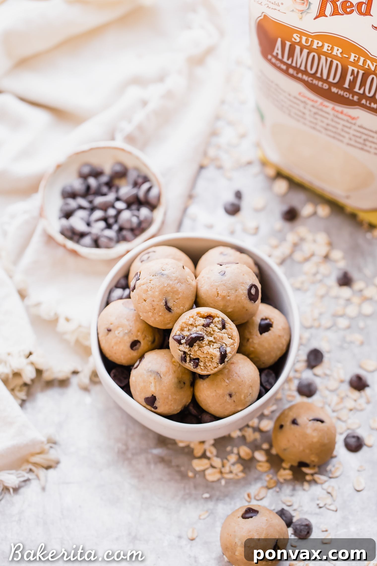 Oatmeal Chocolate Chip Cookie Dough Bites: Gluten Free & Vegan. Stacked in a bowl with oats and chocolate chips.
