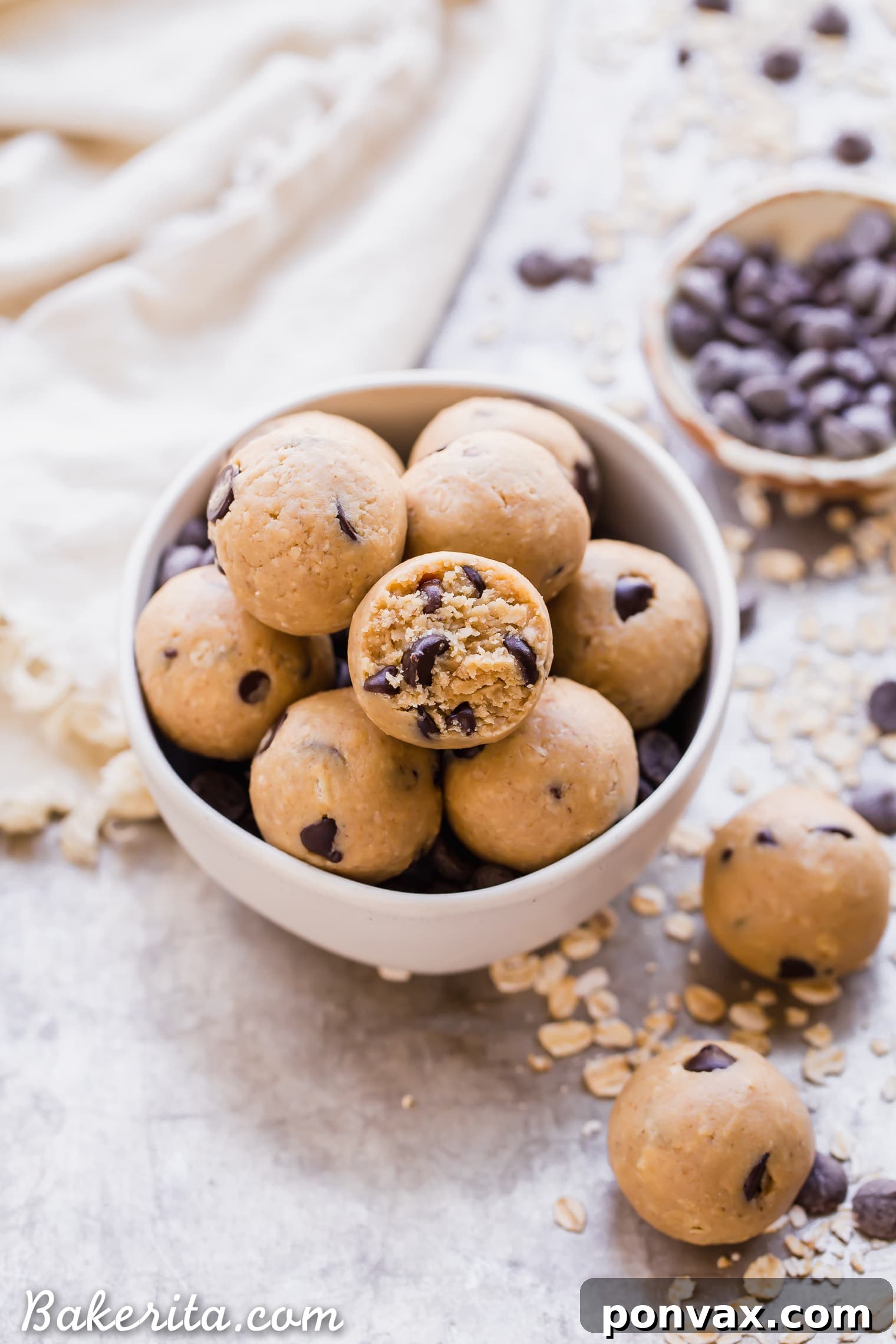 Oatmeal Chocolate Chip Cookie Dough Bites: Gluten Free & Vegan. Stacked in a bowl with oats and chocolate chips.