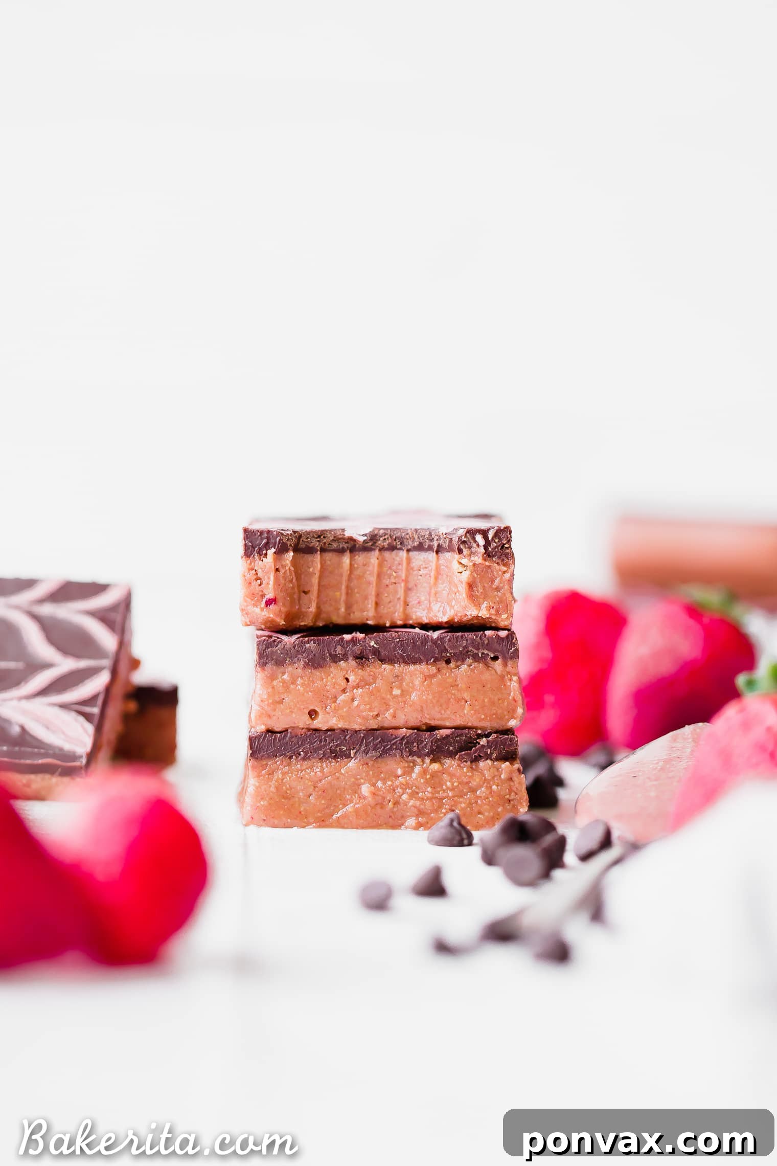 A tray of freshly made No-Bake Chocolate Strawberry Cashew Butter Bars, ready to be chilled and cut. The creamy pink base is visible under a smooth chocolate layer, anticipating a strawberry drizzle.