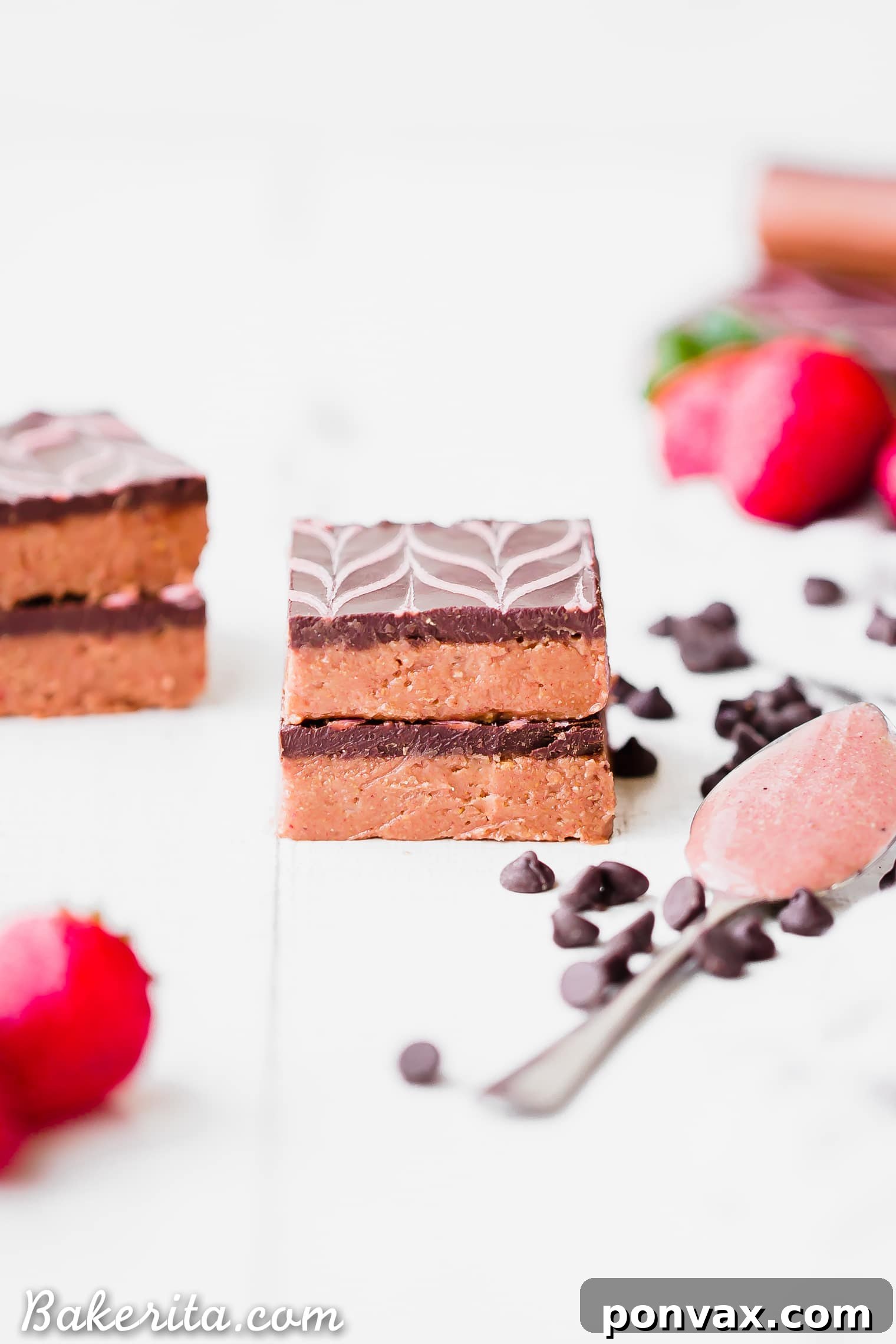A close-up of the delicious No-Bake Chocolate Strawberry Cashew Butter Bars, showing the detailed strawberry drizzle pattern on the dark chocolate topping. These vibrant bars promise a delightful taste.