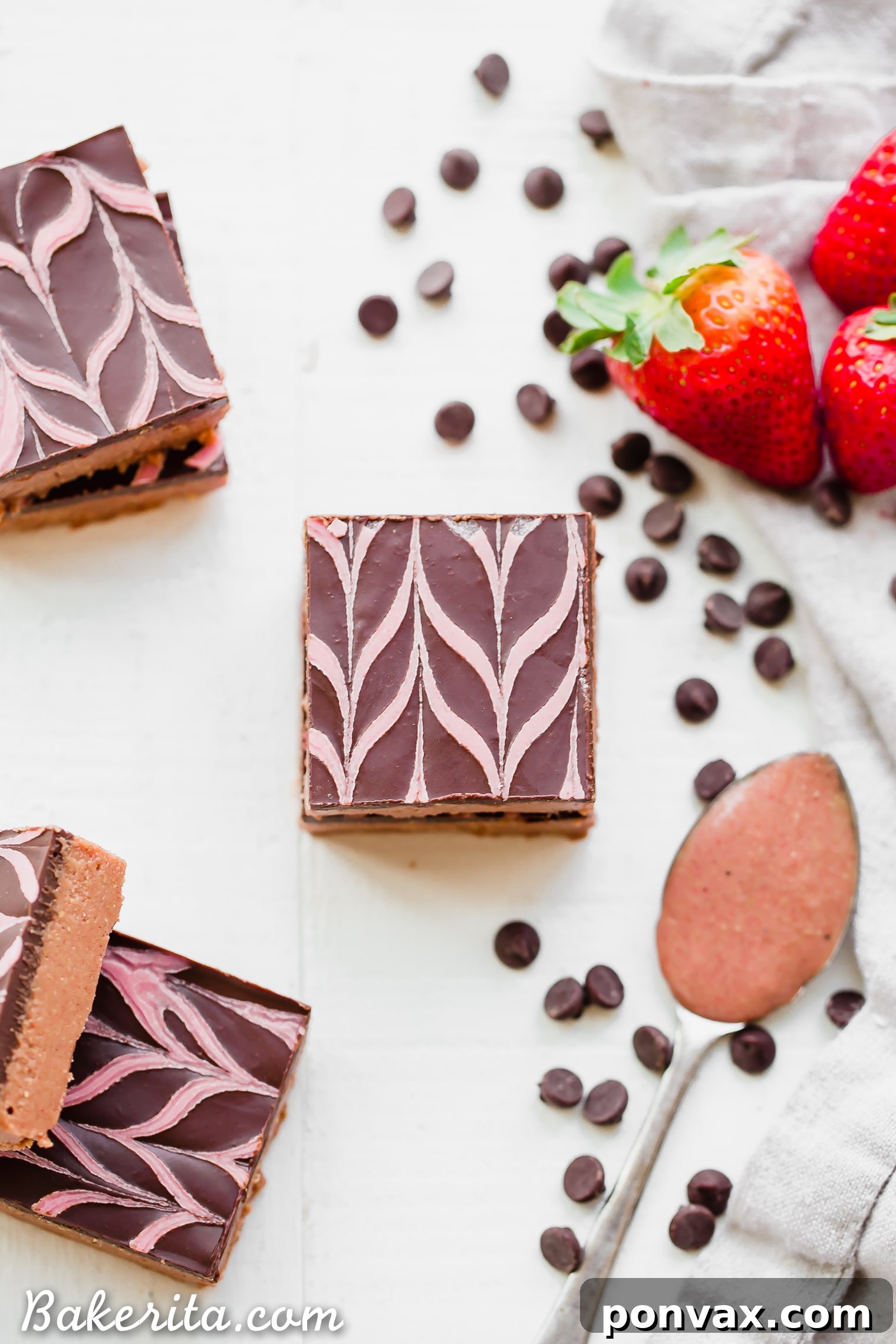 Individual No-Bake Chocolate Strawberry Cashew Butter Bars arranged neatly, showing off their distinct layers and the beautiful pink hue of the strawberry cashew butter base.