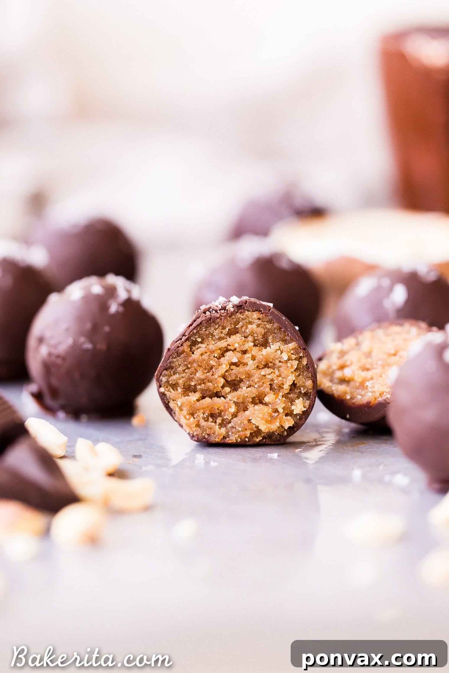 Hand-rolled Chocolate Peanut Butter Truffles dipped in dark chocolate and sprinkled with sea salt, ready to set.