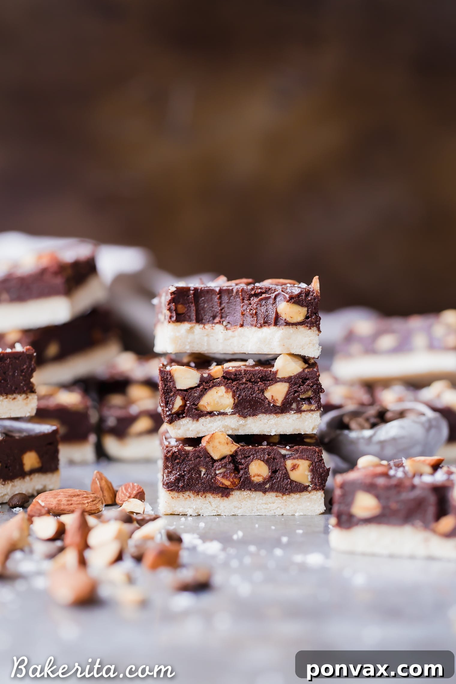 Close-up of a Mocha Almond Fudge Bar, showing the layers of shortbread, dark chocolate and coffee fudge, and a sprinkle of toasted almonds and flaky sea salt.