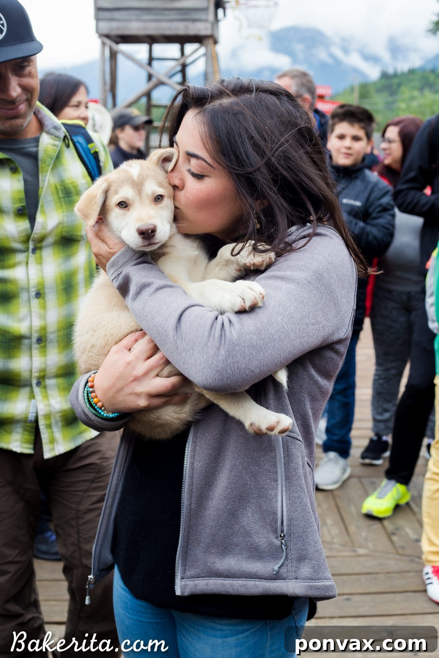 Author happily meeting and playing with adorable sled dog puppies in Alaska
