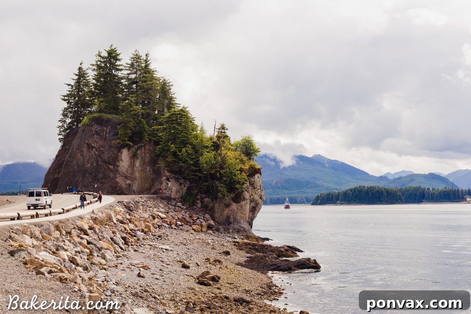 Scenic view of a coastal town nestled by a bay with mountains in the background