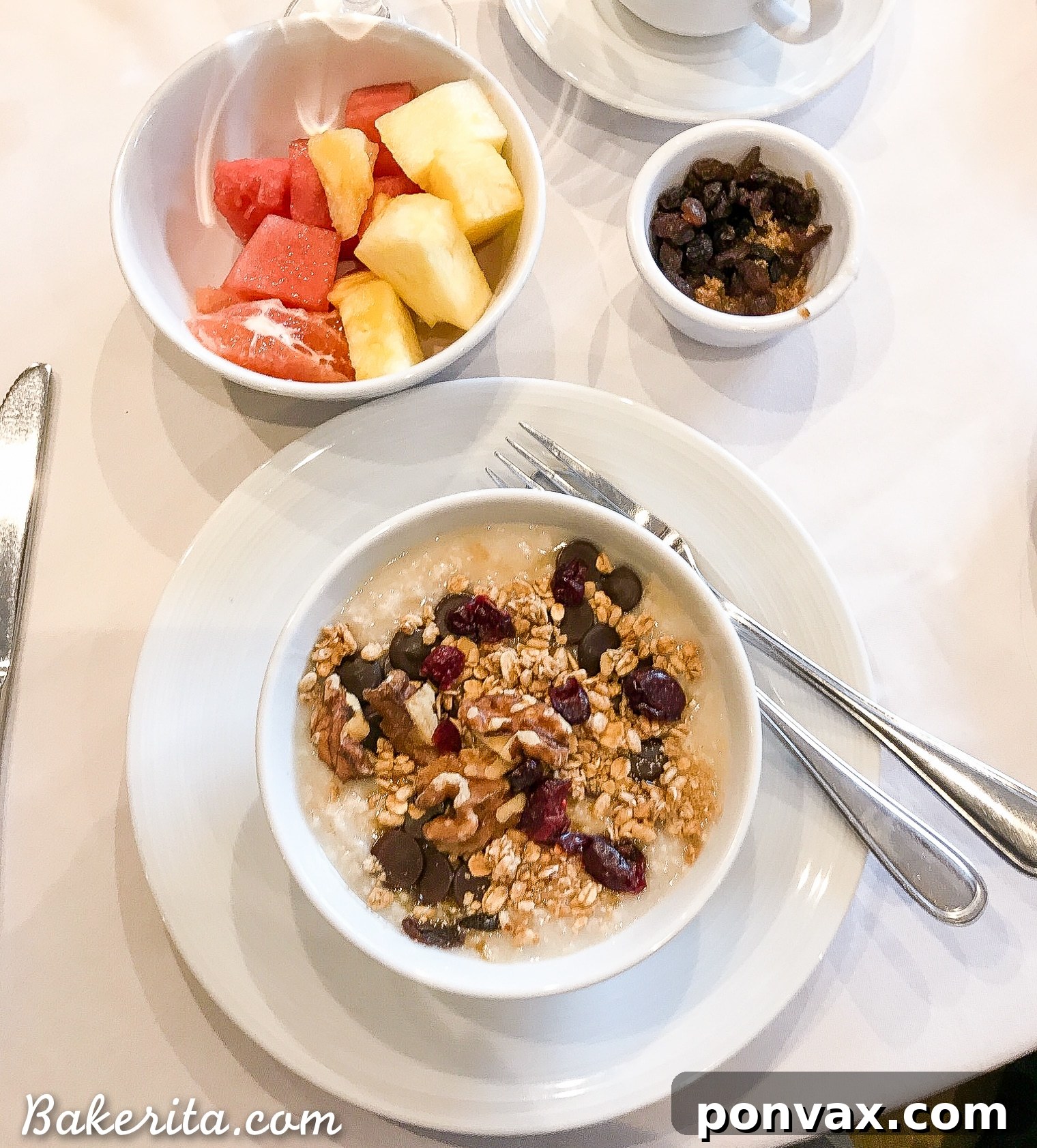 Healthy oatmeal breakfast from the cruise dining room, topped with nuts, dried fruit, chocolate chips, and granola, with fresh fruit on the side.