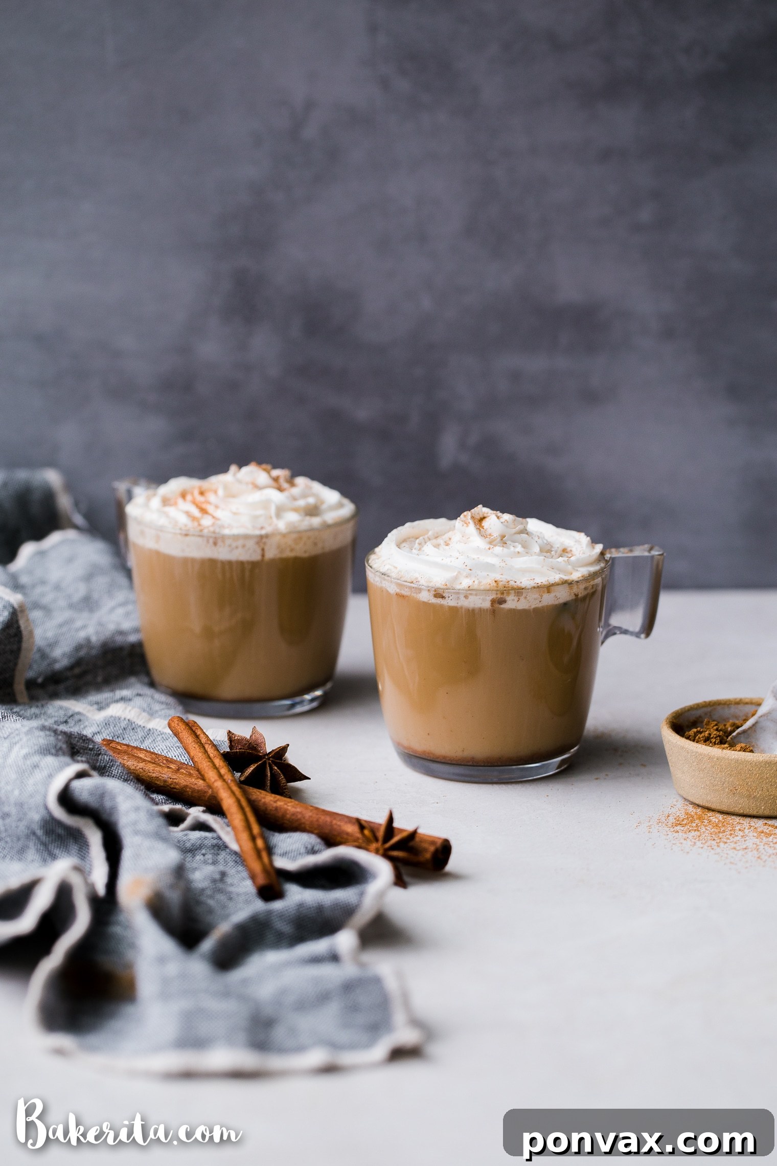 A steaming cup of homemade Vegan Chai Latte, garnished with a sprinkle of chai spice, on a rustic wooden surface next to a cozy blanket, evoking warmth and comfort.